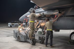 An F-15E Strike Eagle weapons load crew team attaches an AIM-120D to a pylon July 15, 2019, at Al Dhafra Air Base, United Arab Emirates (U.S. Air Force Photo)