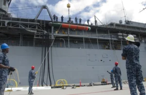 Sailors assigned to the submarine tender USS Frank Cable's (AS 40) weapons department, stabilize a Mark 48 heavyweight torpedo during a weapons on-load in February 2017 (Photo: U.S. Navy by Mass Communication Specialist 3rd Class Alana Langdon/Released)