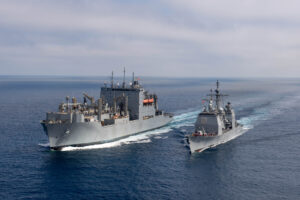 The Ticonderoga-class guided-missile cruiser USS Chosin (CG-65) steams alongside the Lewis and Clark-class dry cargo ship USNS Washington Chambers (T-AKE 11) during an at-sea demonstration of the Transferrable Reload At-sea Method (TRAM) to reload an Mk 41 Vertical Launching System while underway off the coast of San Diego, Calif. on Oct. 11, 2024. (Photo: U.S. Navy by Mass Communication Specialist 2nd Class Charlotte Dudenhoeffer)