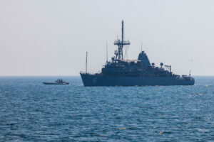 The Avenger-class mine countermeasures ship USS Devastator (MCM 6) sails alongside an unmanned surface vessel, attached to U.S. Naval Forces Central Command’s Task Force 59, during exercise Digital Talon 3.0 in the U.S. Central Command area of responsibility on Nov. 5. (Photo: U.S. Army)